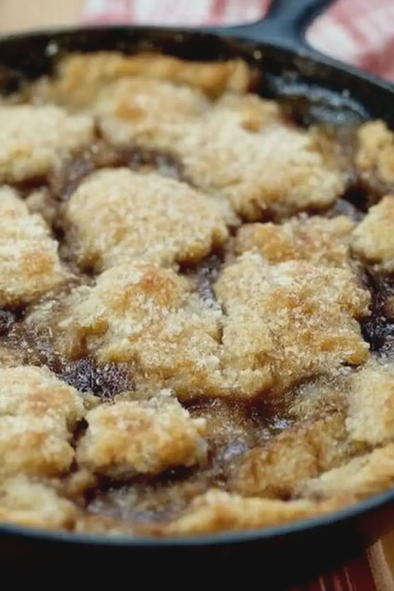 Delicious bourbon apple pandowdy with golden crust and apple slices, perfect for dessert.